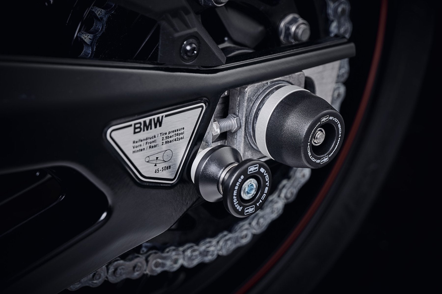 The nearside of the rear wheel of the BMW M 1000 R with EP Spindle Bobbins Crash Protection attached, guarding the swingarm and chain.